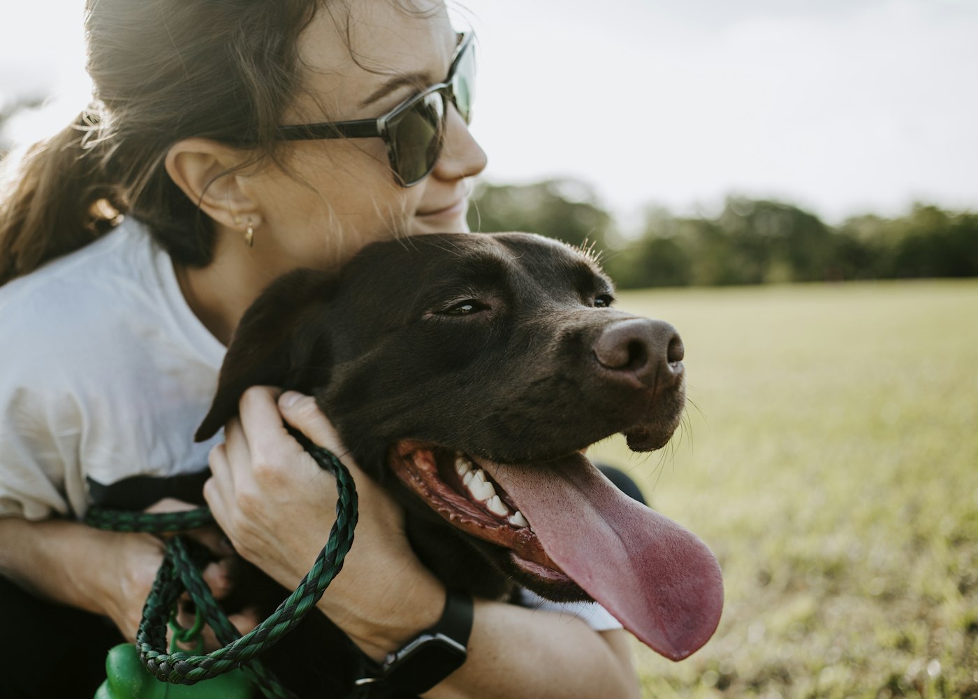 Happy pet parent hugging her dog
